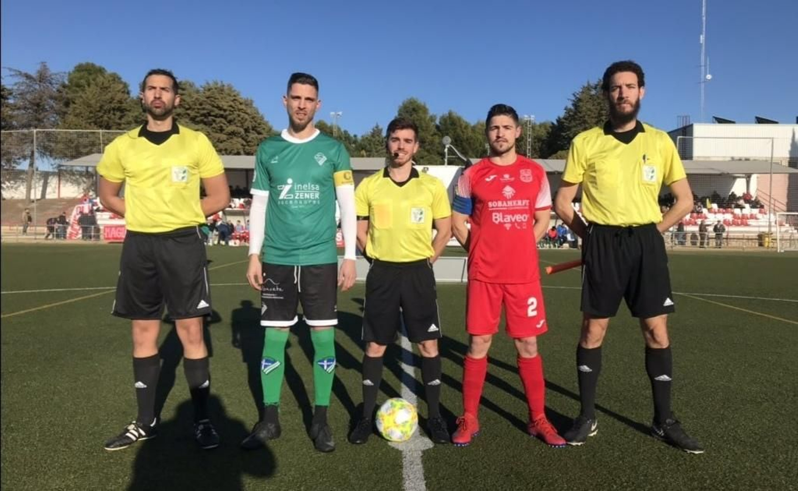 Los capitanes con el trío arbitral.