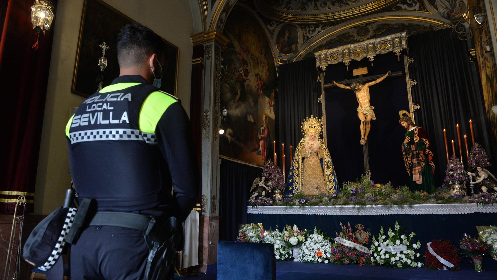 Un Policía Local ante los titulares de los Negritos el pasado Jueves Santo.