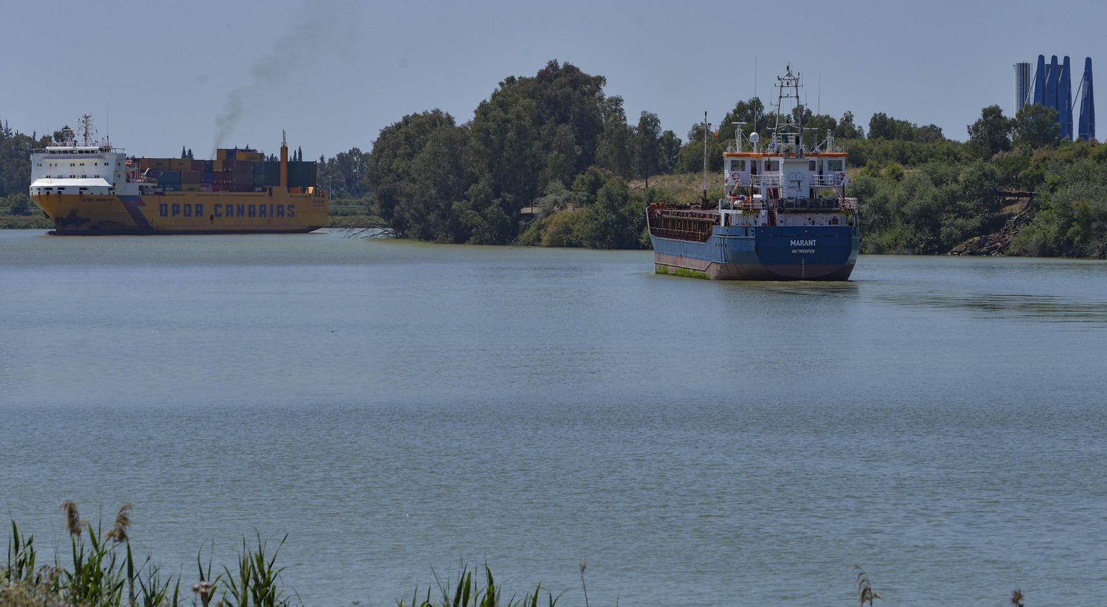 Dos barcos navegan por la dársena del Puerto y, de lejos, la esclusa.