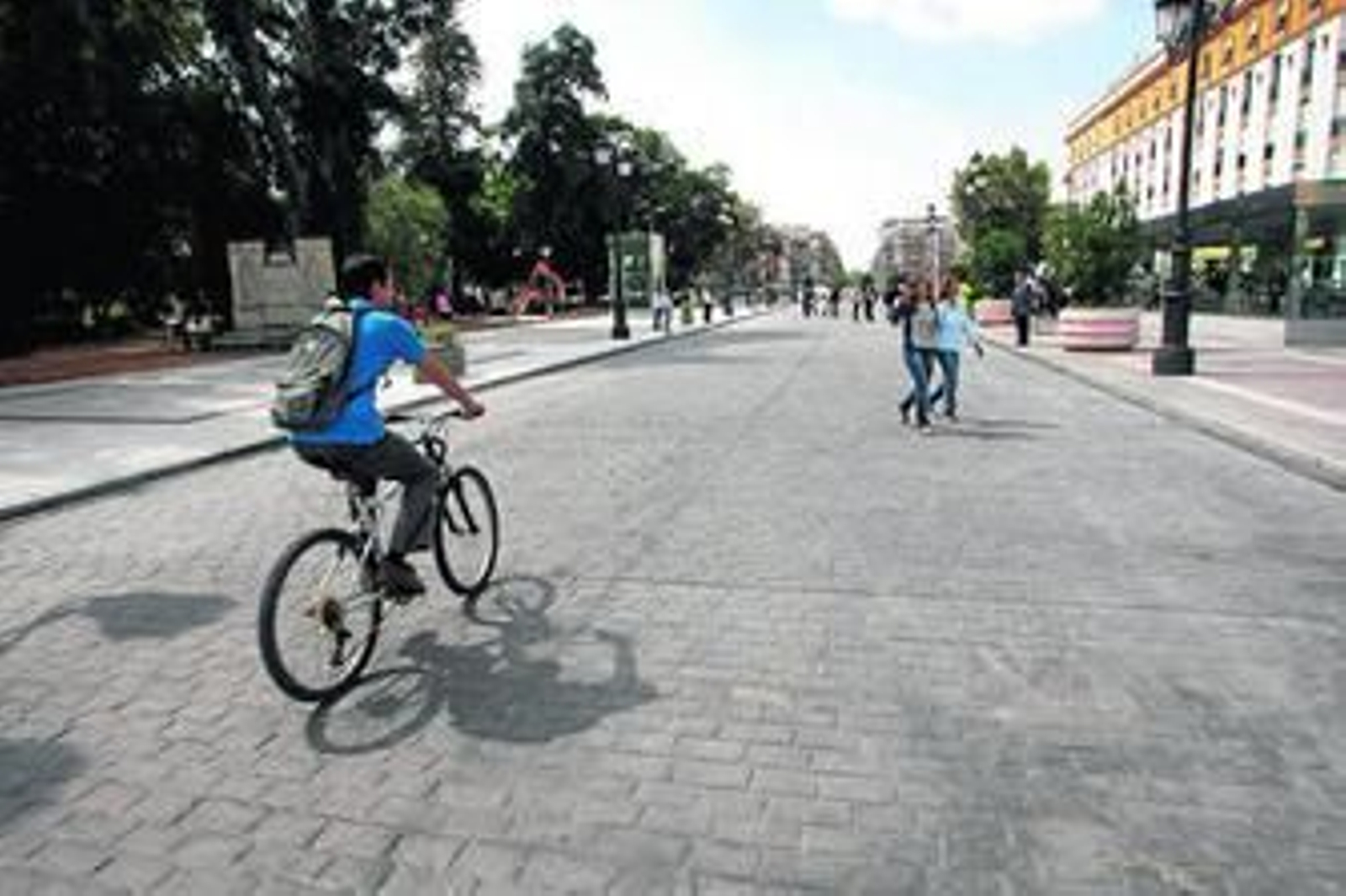 Un ciclista cruza por la calzada del Cristina, que ahora es peatonal con macetones provisionales.