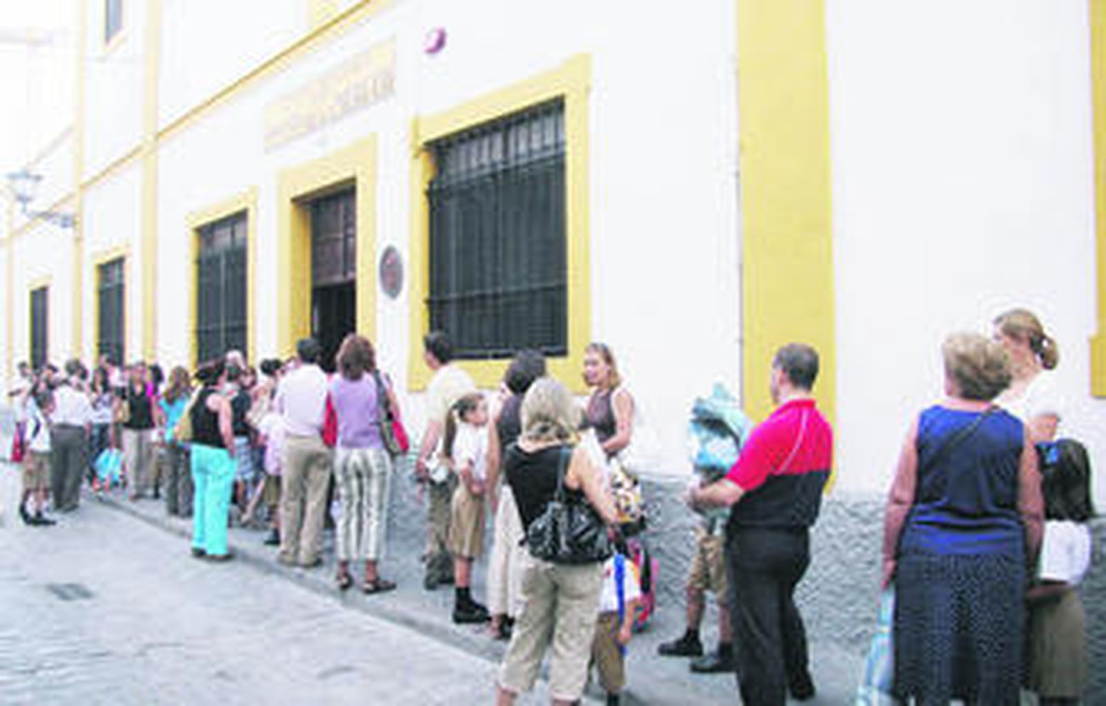 Padres y alumnos aguardan la apertura de puertas del colegio de la Merced, en el casco antiguo, en la estrecha acera de acceso al centro.