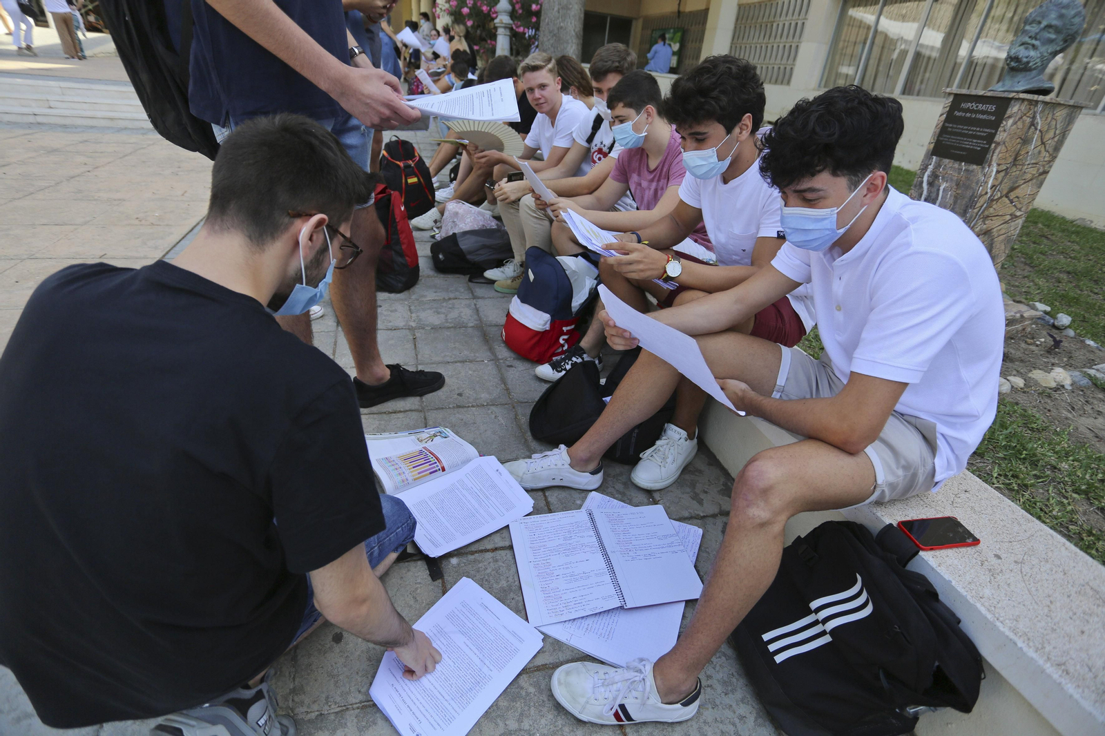 Alumnos repasan sus apuntes en el exterior del aula.