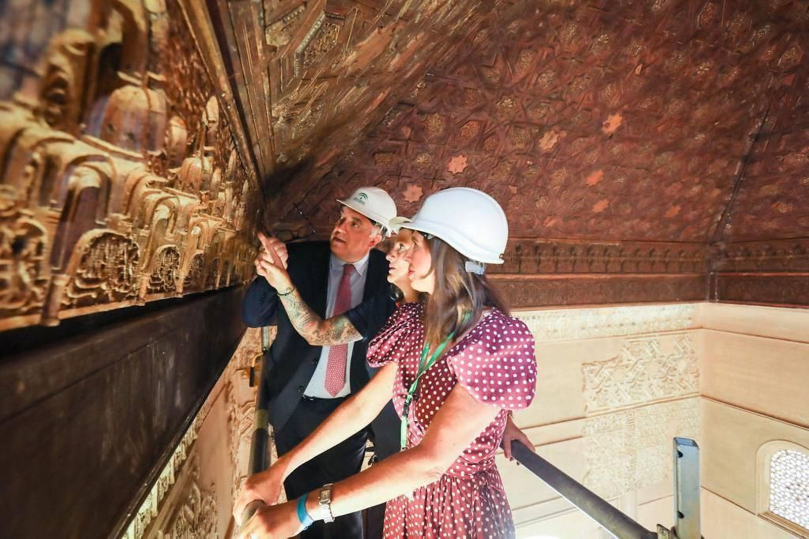 El consejero de Turismo, Arturo Bernal, comprueba junto a la directora del Patronato, Rocía Díaz, y una restauradora, el estado de la pieza recuperada en La Alhambra