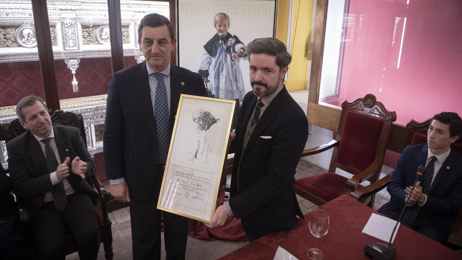 El hermano mayor de los Estudiantes, Jesús Resa, entrega una distinción al pregonero.