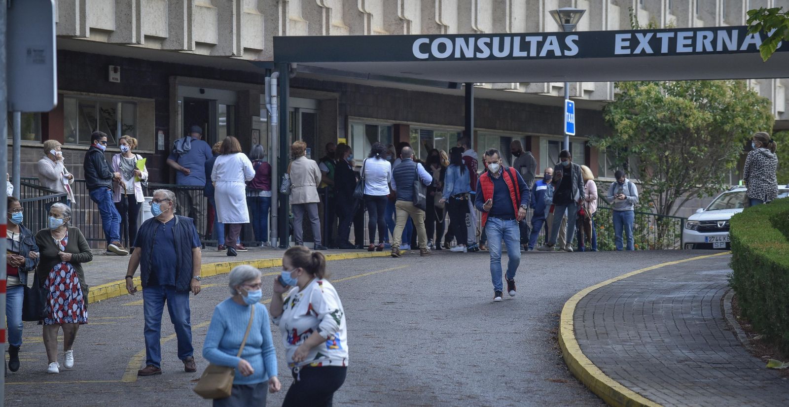 Pacientes y acompañantes en la entrada a la unidad de consultas externas del Hospital Virgen del Rocío