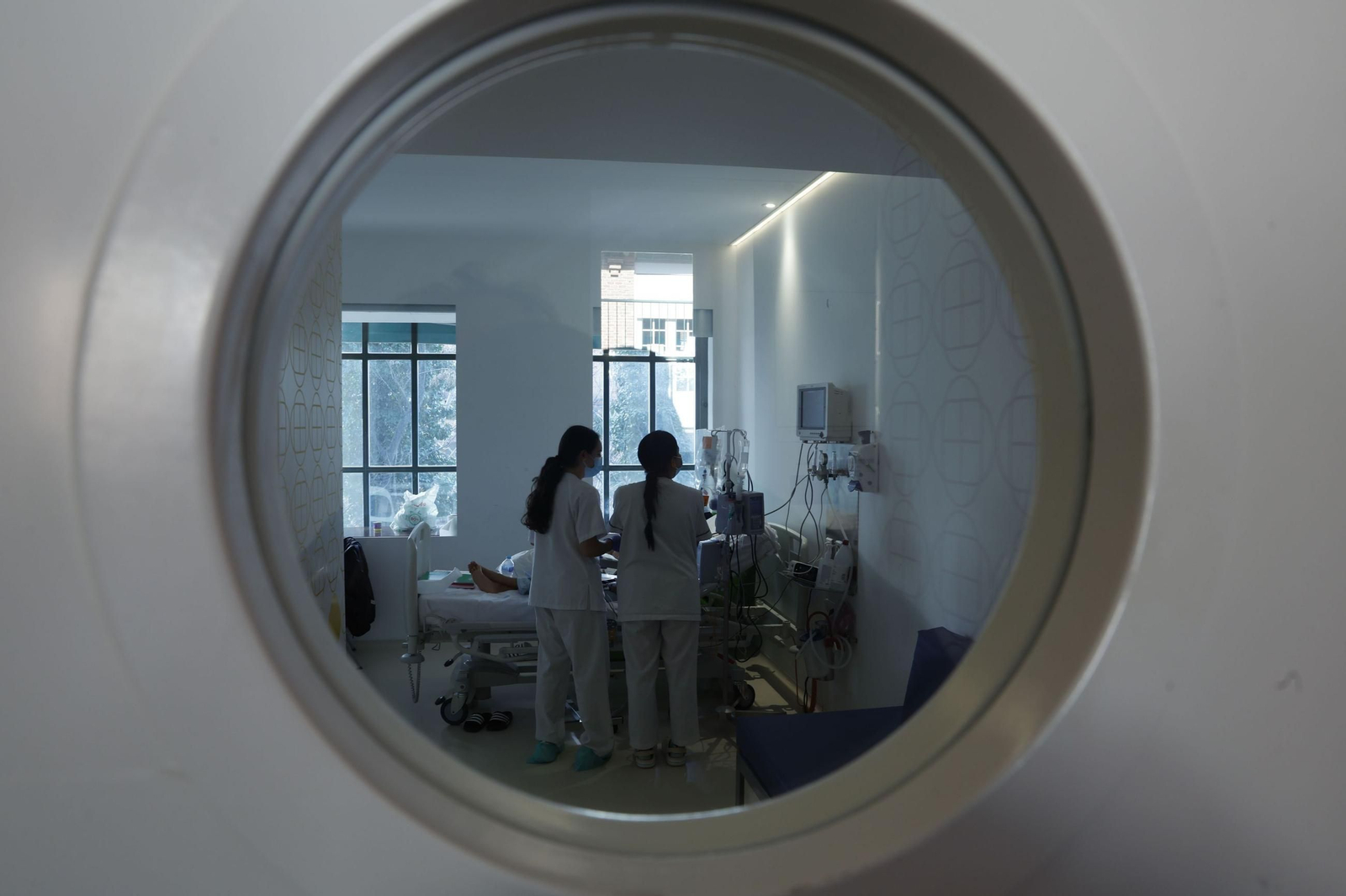 Varias enfermeras atienden a un niño con cáncer en el Hospital púbico infantil Niño Jesús.