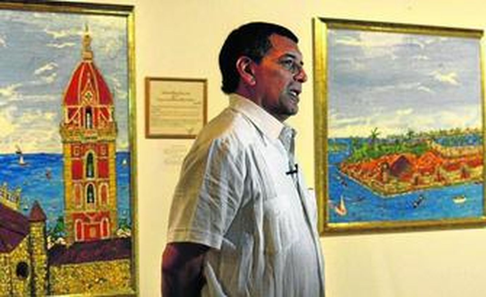 El artista Mario Acuña, Makú, ante dos de las obras que expone hasta octubre en Santa Catalina.