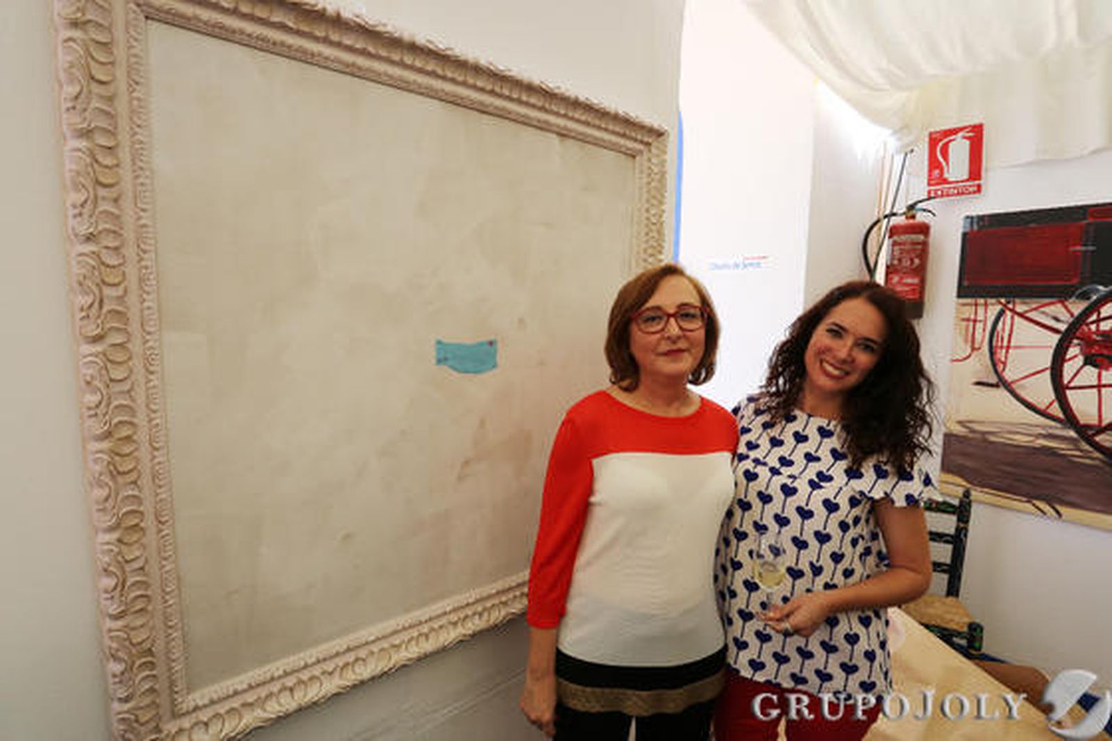 Mercedes Santos y su hija Mercedes, junto al trabajo de la autora. 

Foto: Pascual