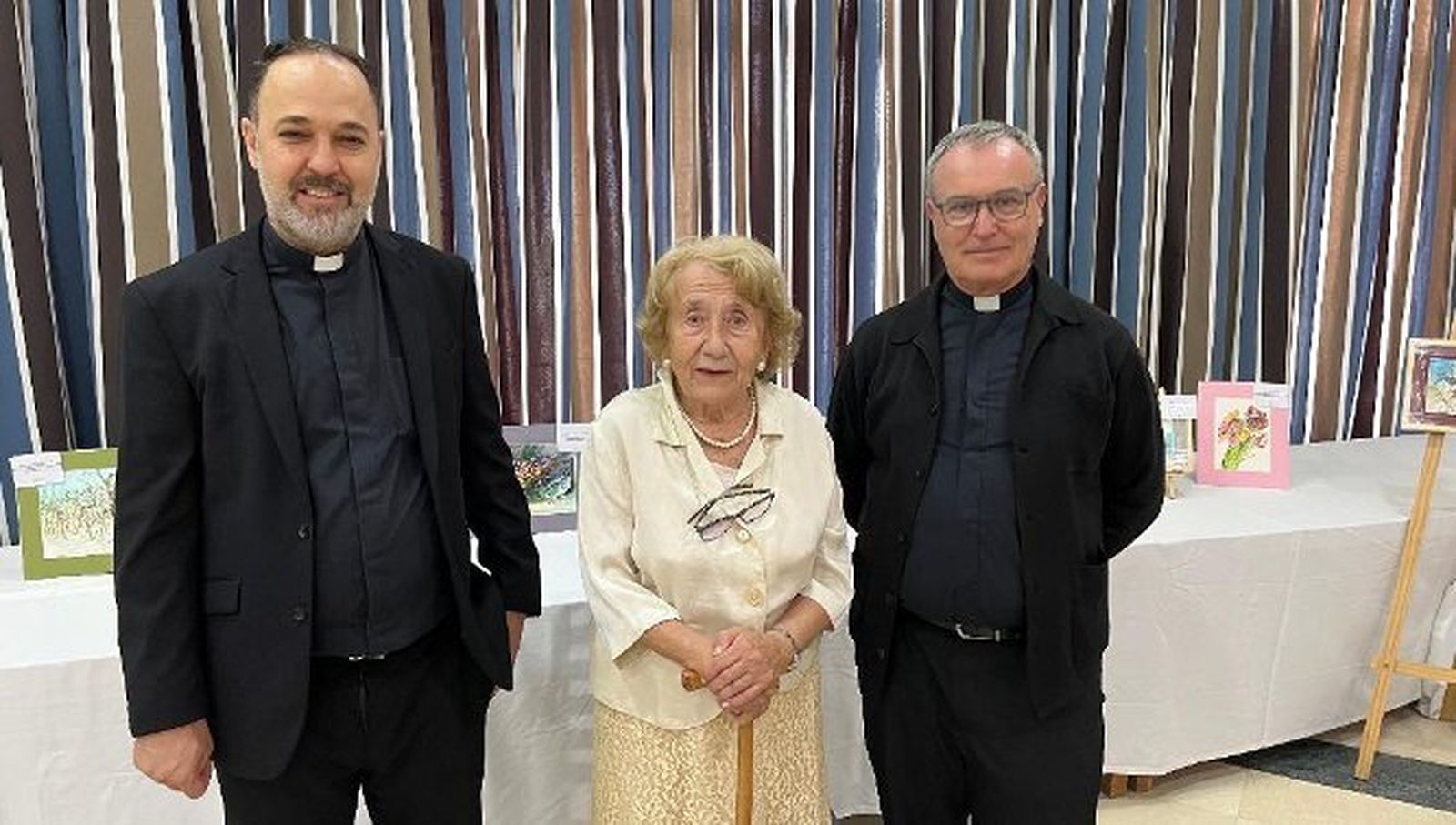 La pintora  María Teresa Benavides con el padre Antonio Sabina y el padre Alfonso Guerrero, durante la inauguración de la exposición de pinturas en el hotel Puerto Bahía, en El Puerto de Santa María.