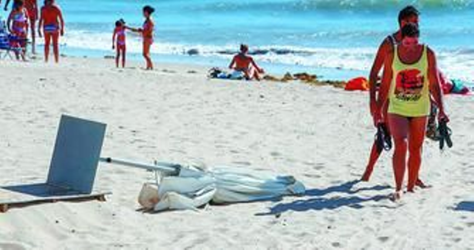Una de las sombrillas de un chiringuito caída en el suelo, tras ser derribada ayer por el levante.