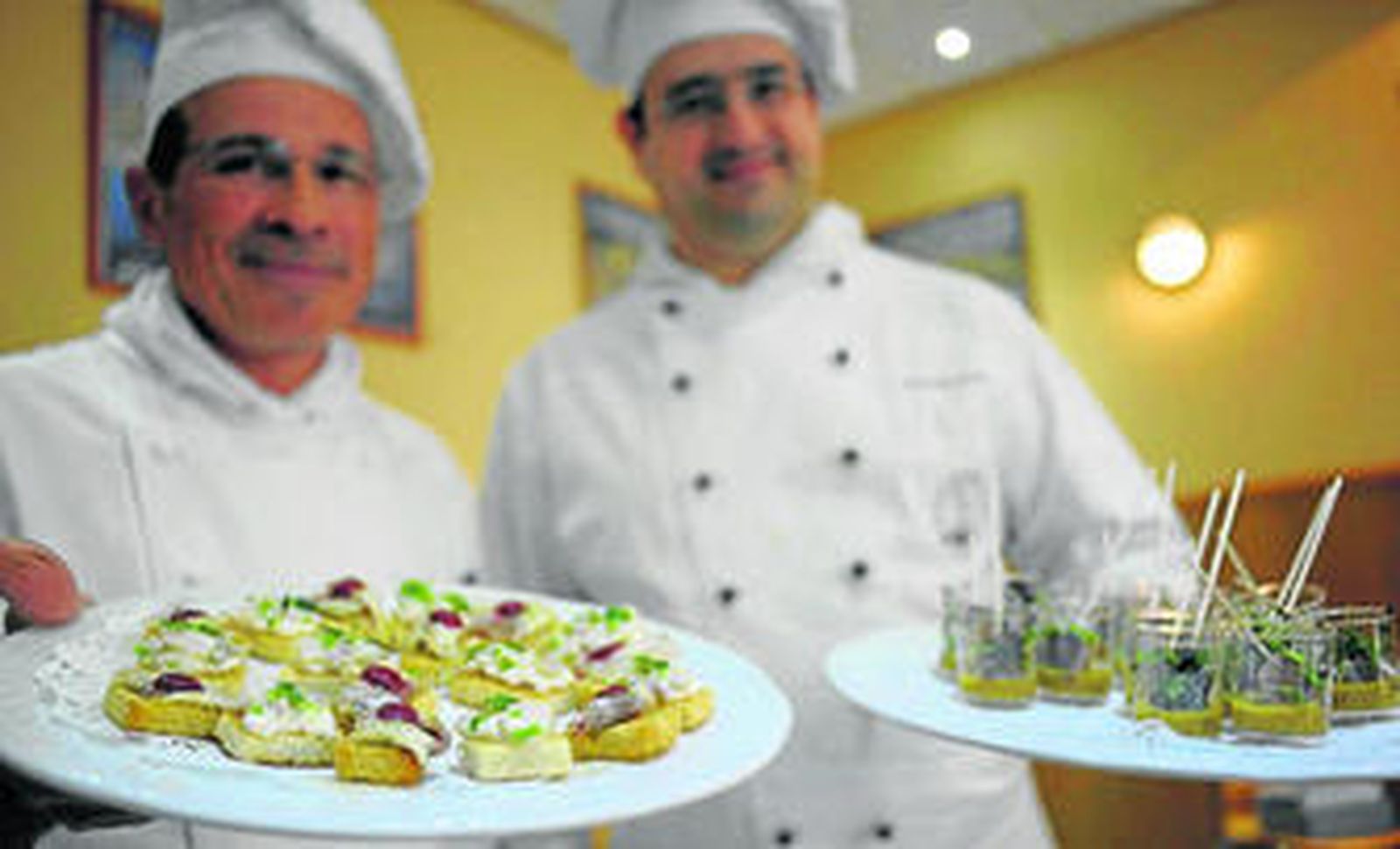 Manuel Rodríguez y Juan Ramón González muestran algunos de los platos elaborados con pescados de estero.
