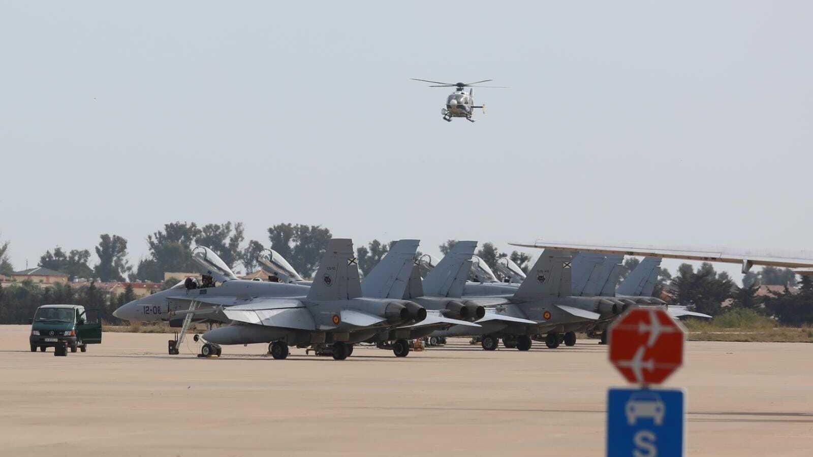 Un helicóptero vuela sobre los cazas en la Base Aérea de Málaga.