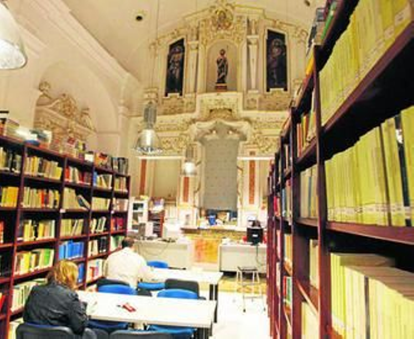 Dos alumnos de la UNED, en la biblioteca del centro.
