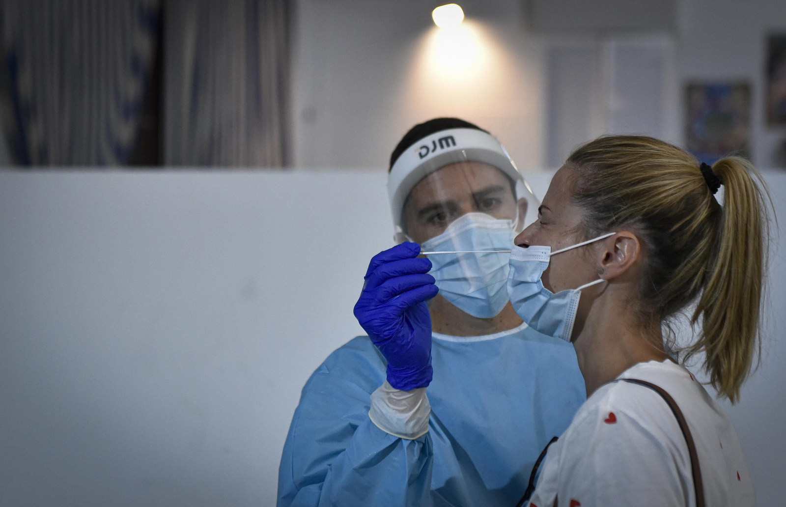 Una mujer se prepara para una toma de muestras de una prueba de antígenos.