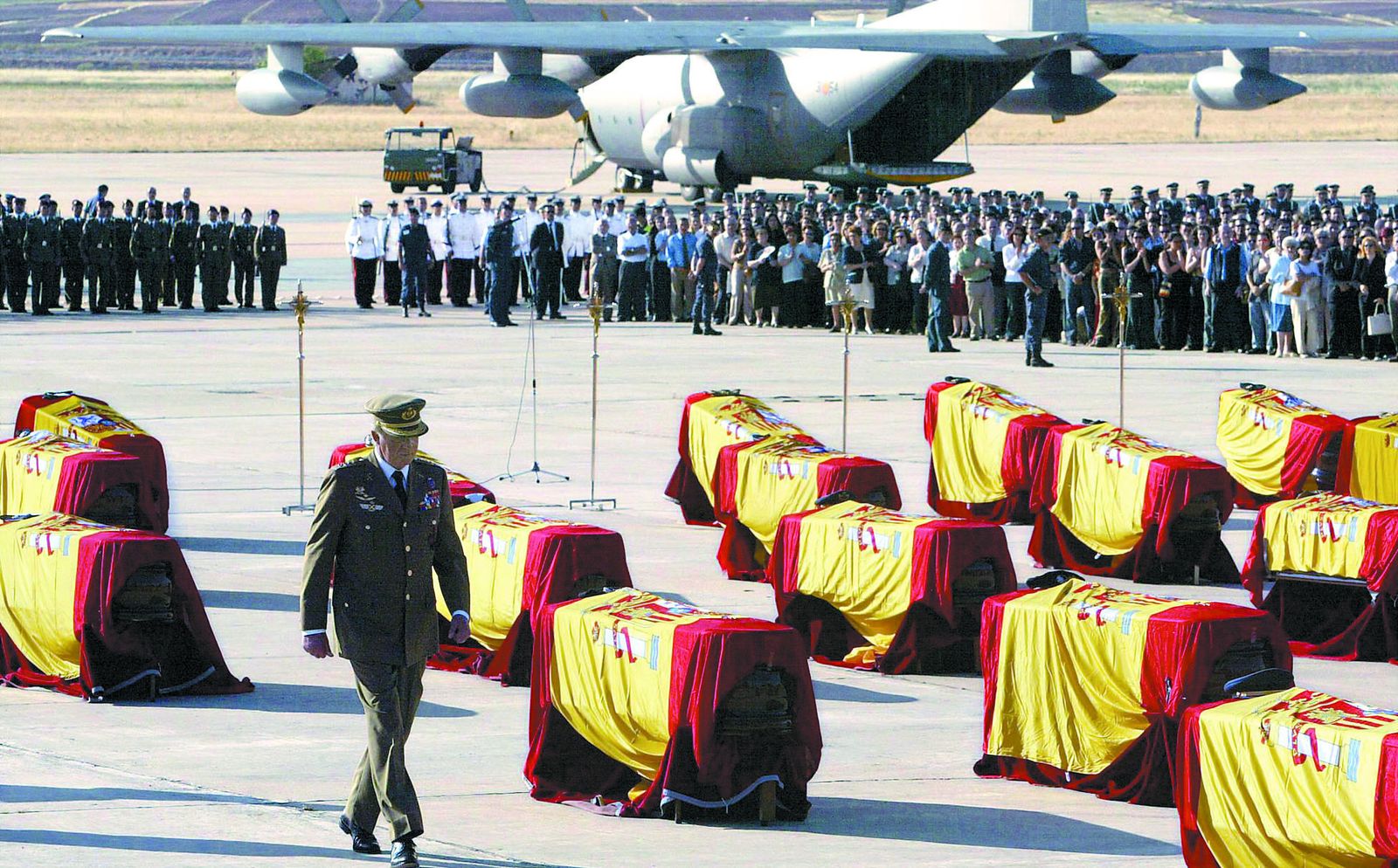 El rey Don Juan Carlos impuso condecoraciones a título póstumo sobre los 62 féretros de los militares muertos en el accidente del Yak-42, colocados en la pista de la base aérea de Torrejón.