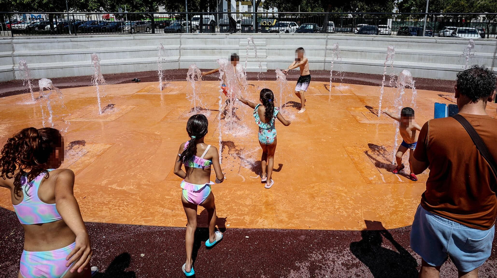 Varios niños, refrescándose en una fuente de la ciudad. Varios niños, refrescándose en una fuente de la ciudad.