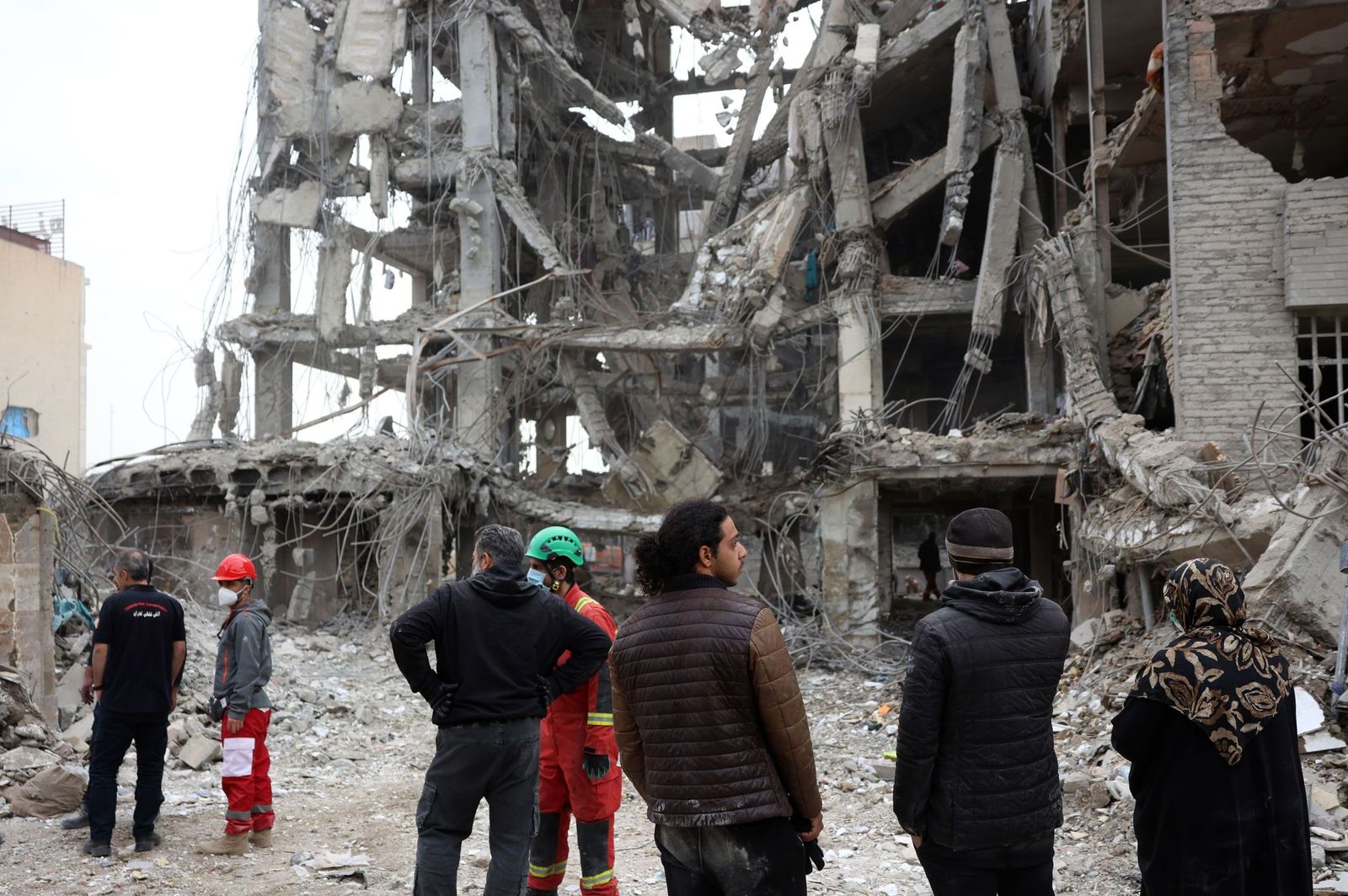 Varios iraníes observan los restos de un edificio residencial bombardeado en Teherán.