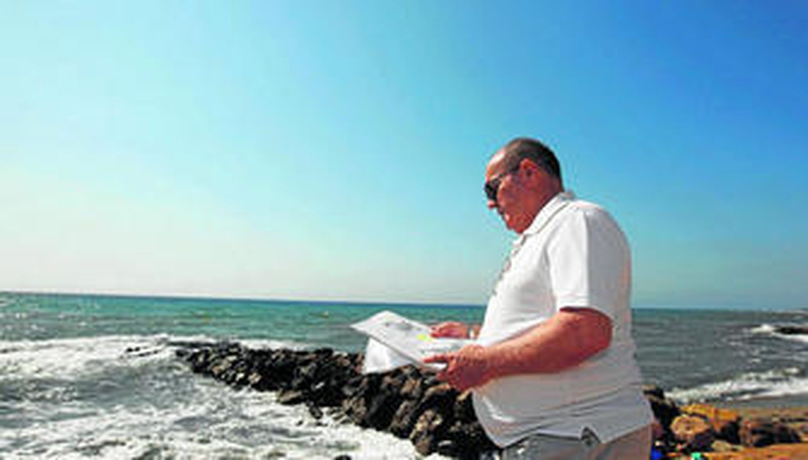 José Ortiz, guardia civil que realizó trabajos de vigilancia durante años en Palomares, mira los documentos con los que trata de demostrar su verdad.