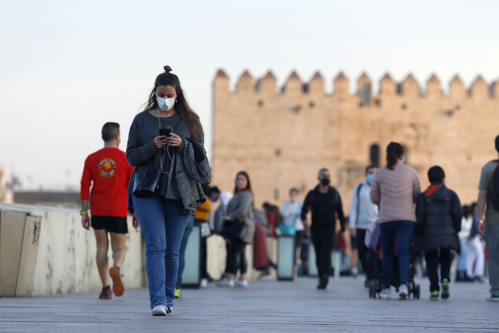 Varias personas pasean por el Puente Romano.