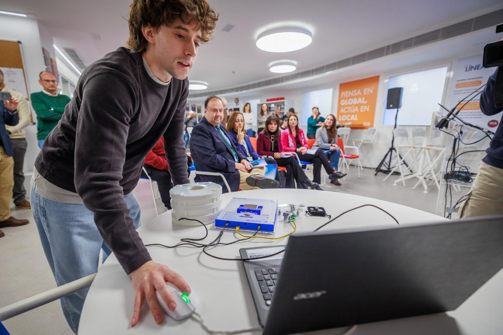 José Dodero muestra uno de los dispositivos para digitalizar monedas ante la atenta mirada del rector y las vicerrectoras de la Universidad de Cádiz.