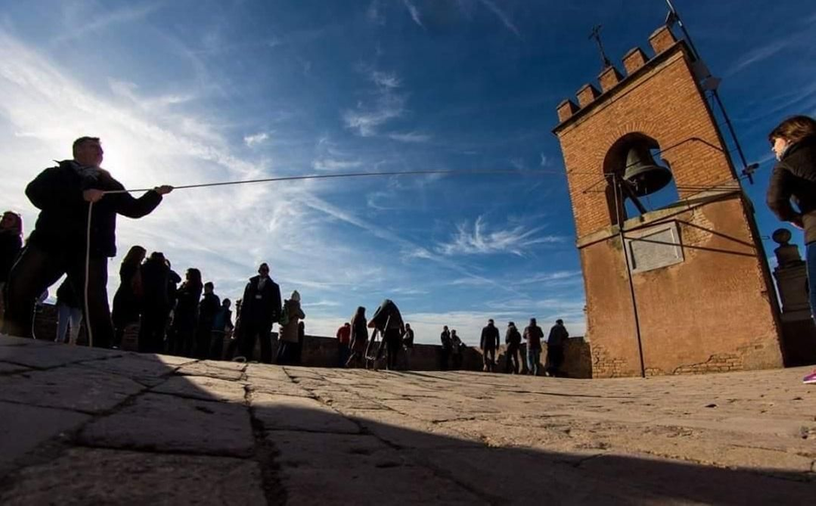Imagen de un ciudadano tocando la campana de la Torre de la Vela de Granada
