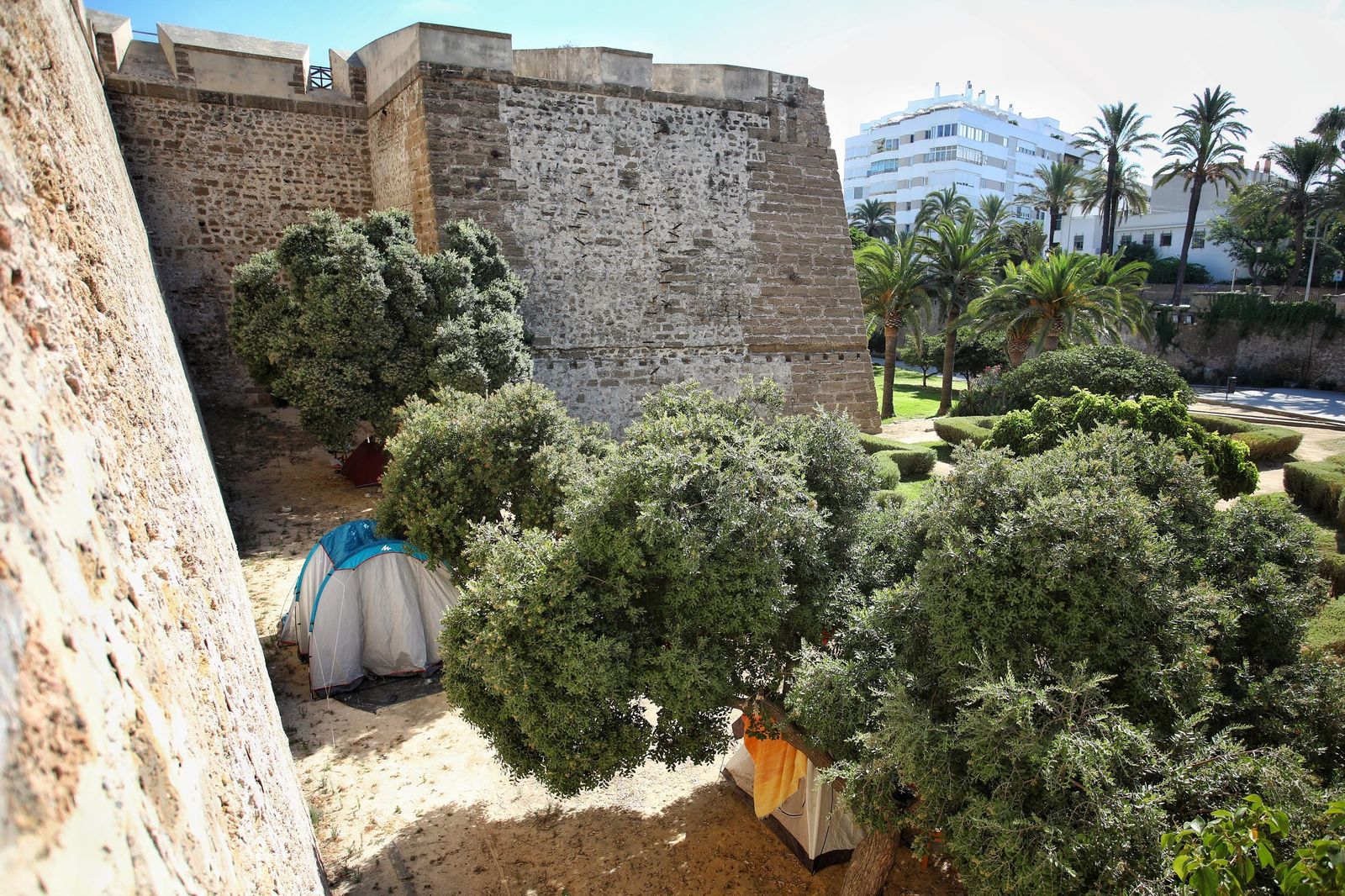 Varias tiendas de campañas instaladas por personas sin hogar en el foso de las Puertas de Tierra, a los pies de la muralla.
