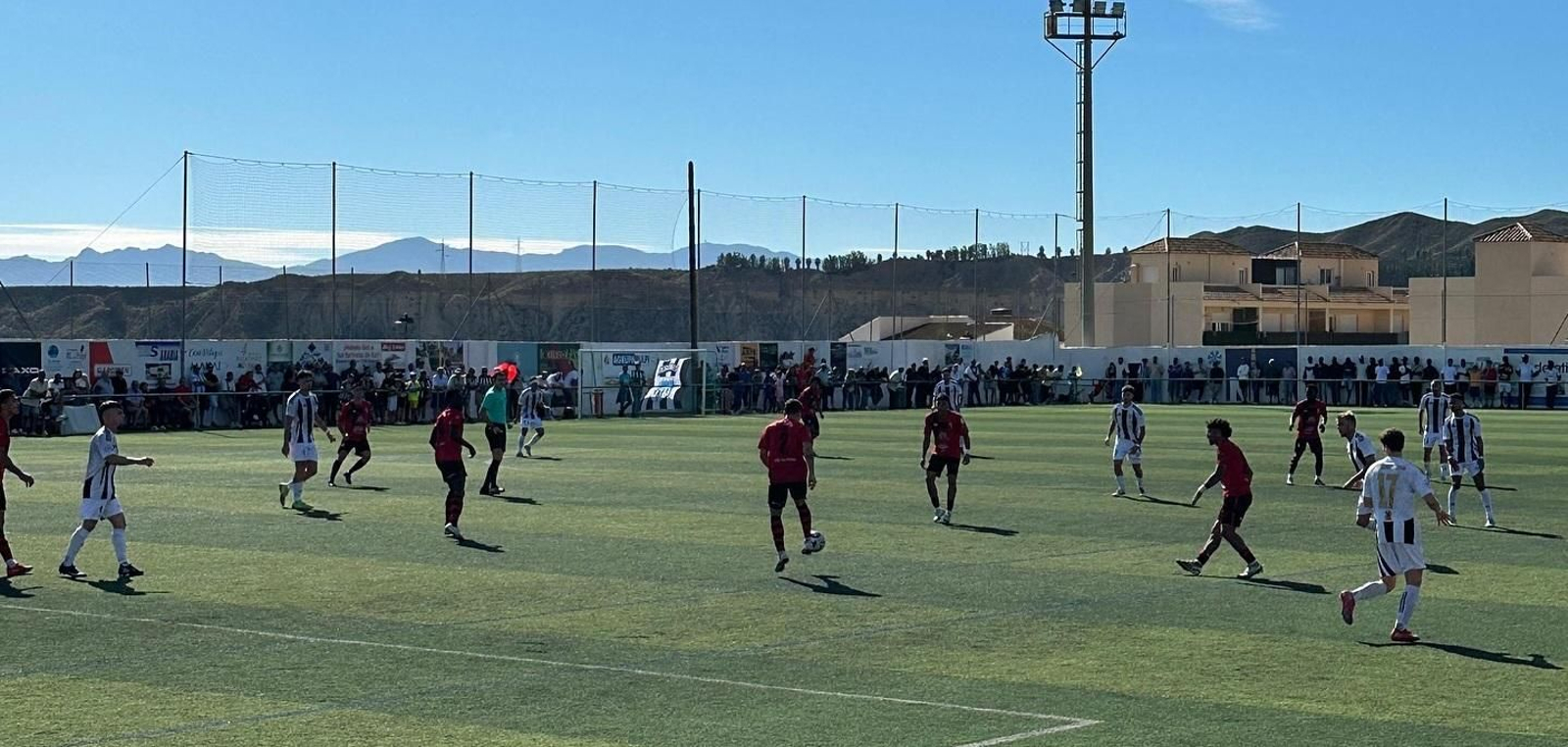 Un jugador rojinegro con el balón en su posesión durante el derbi almeriense que enfrentó al Cuevas y al Garrucha.