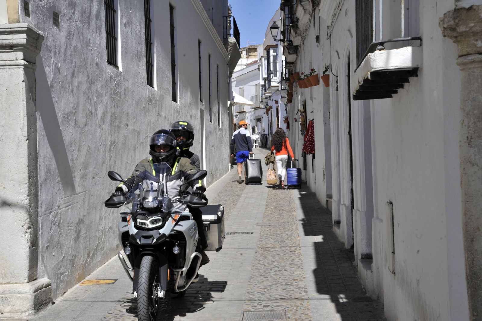 Varios turistasen moto  por una calle de Arcos