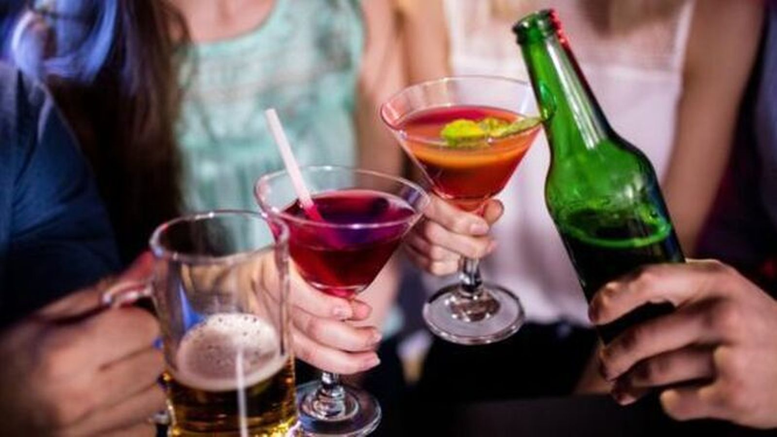 Unos jóvenes brindan con cervezas y bebidas con alcohol.