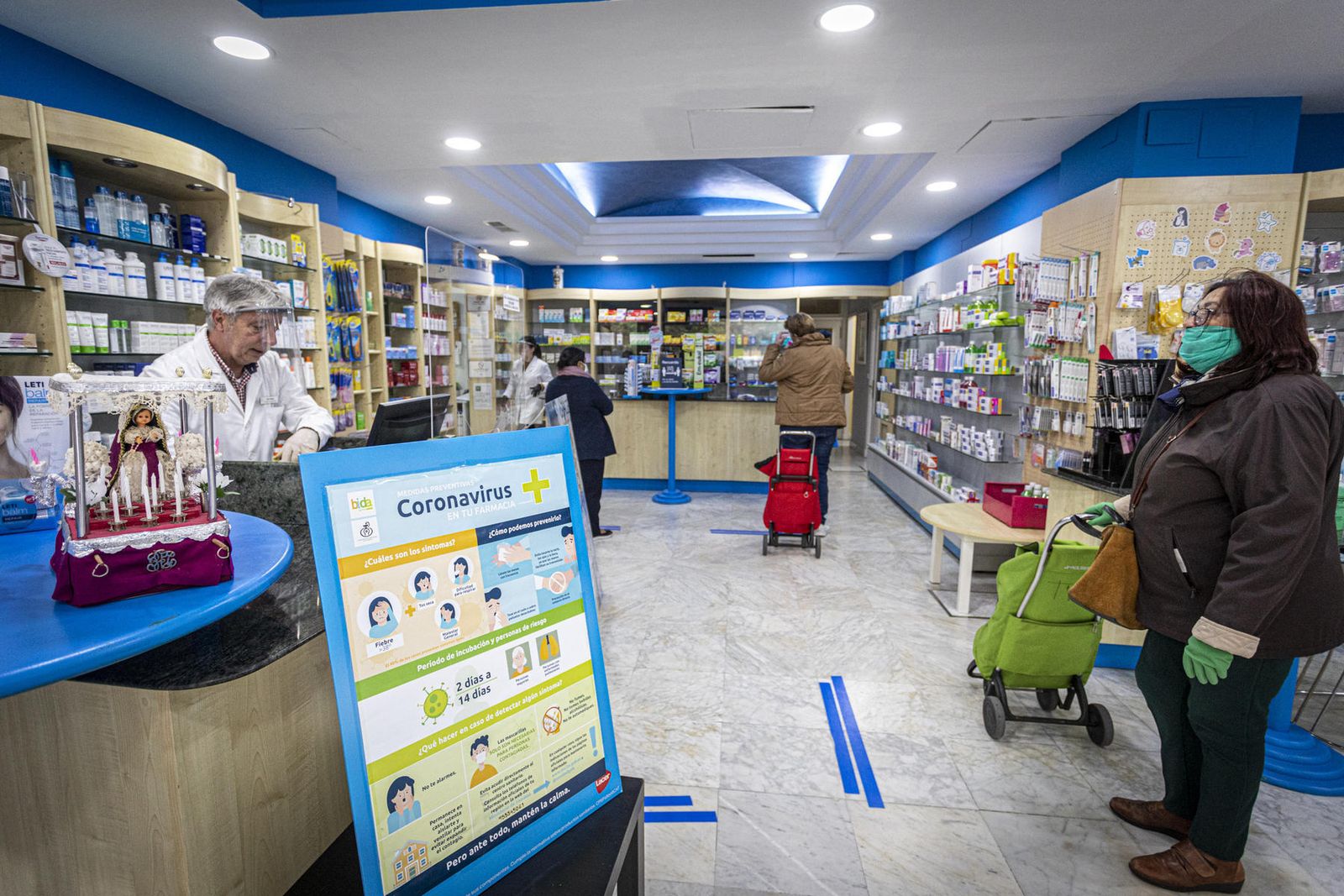 reportaje gráfico: jesús marín Pedro, de la farmacia Beltrami, en la plaza Pintor Clemente de Torres, corazón del barrio, atiende a una cliente.