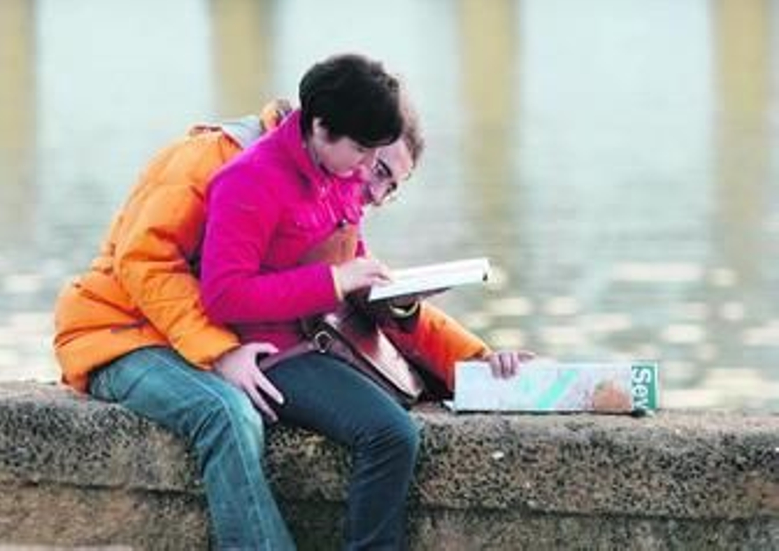 Una pareja consulta un mapa y una guía de Sevilla junto al río Guadalquivir, ayer por la tarde.