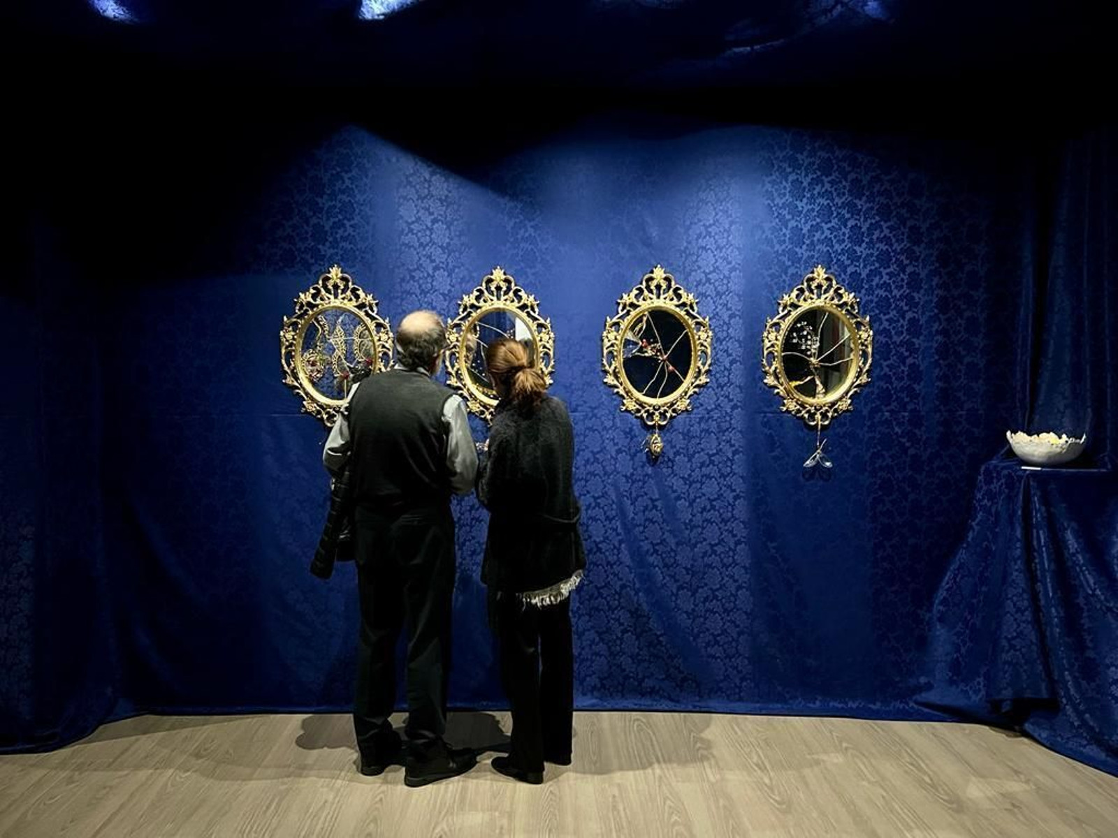 Dos visitantes contemplas las obras.