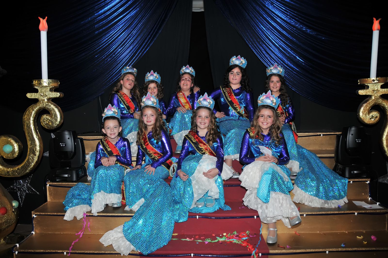 La reina infantil -en el centro en la fila superior- rodeada de las damas.