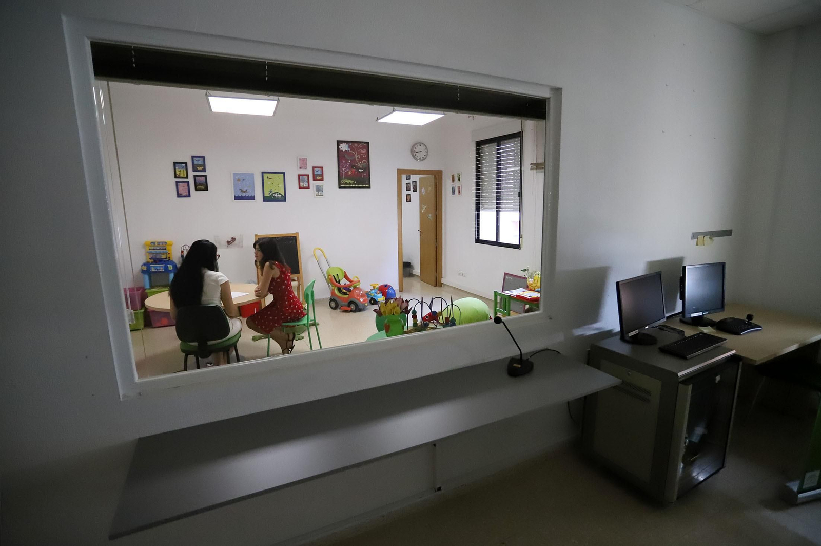 Dos especialistas del SAVA en la sala Gesell. En primer término, la habitación donde se ubica la comisión judicial y desde donde se graba el testimonio obtenido al otro lado.