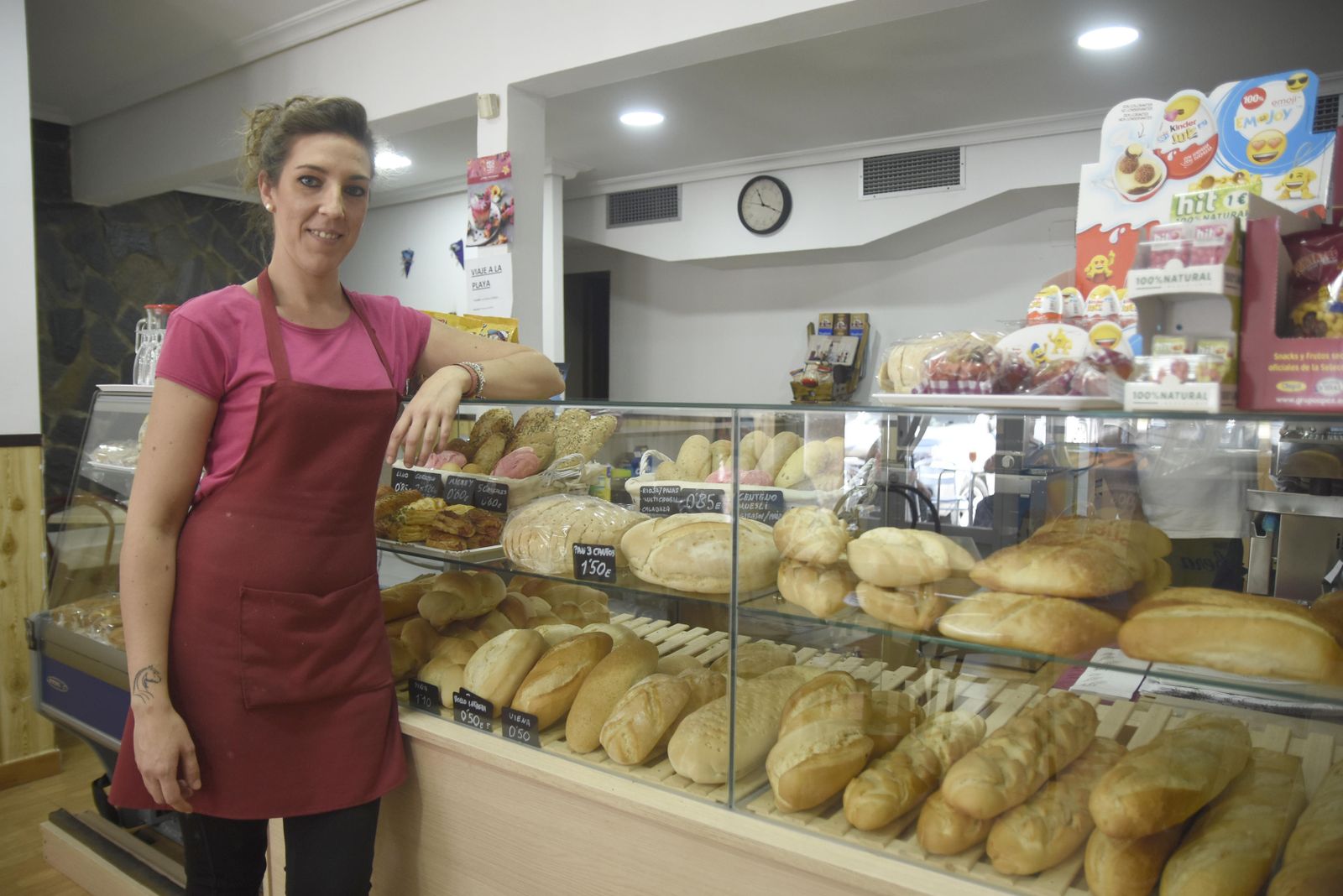 Ana María Benzal, junto a la vitrina de su panadería, cargada de todas las variedades de pan que ofrece en su cafetería.