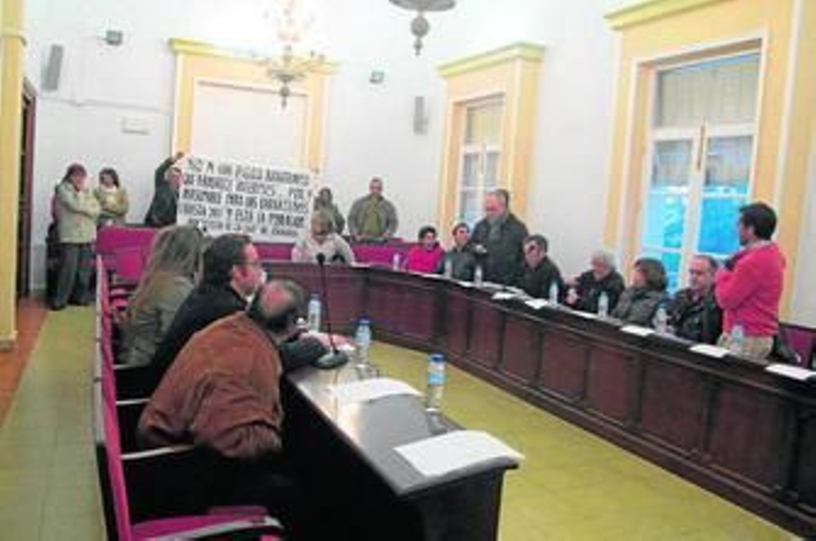 Un instante del pleno en el que los vecinos de Zahora exponen sus críticas al PGOU en una pancarta.