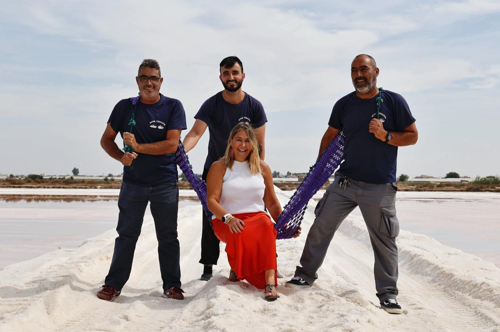 Bea Bartel sobre uno de sus diseños realizado con antiguas redes de pesca por las manos artesanas que la sujetan