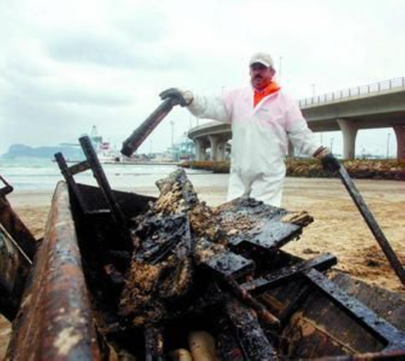 Un operario recoge restos manchados por el fuel proveniente del 'New Flame'.