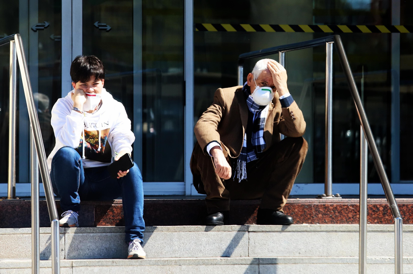 Imagen de dos personas en la puerta de acceso al hospital Juan Ramón Jiménez.