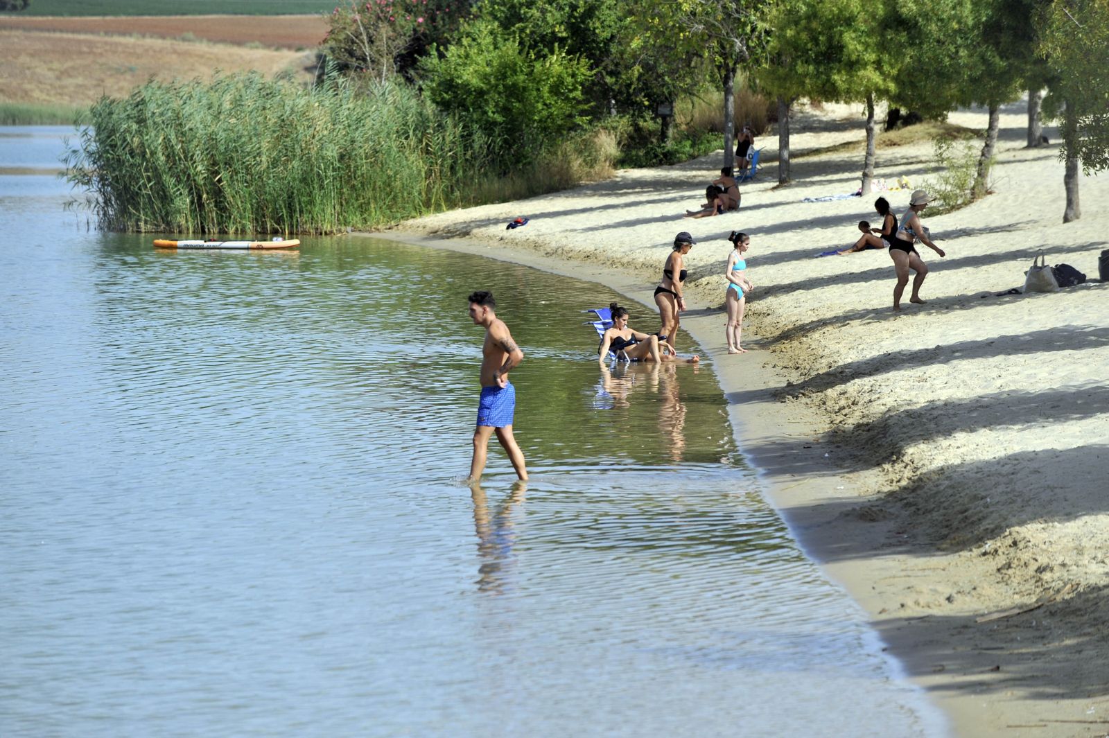 Varios bañistas, en una imagen de este verano en la playa artificial habilitada en el lago de Arcos.