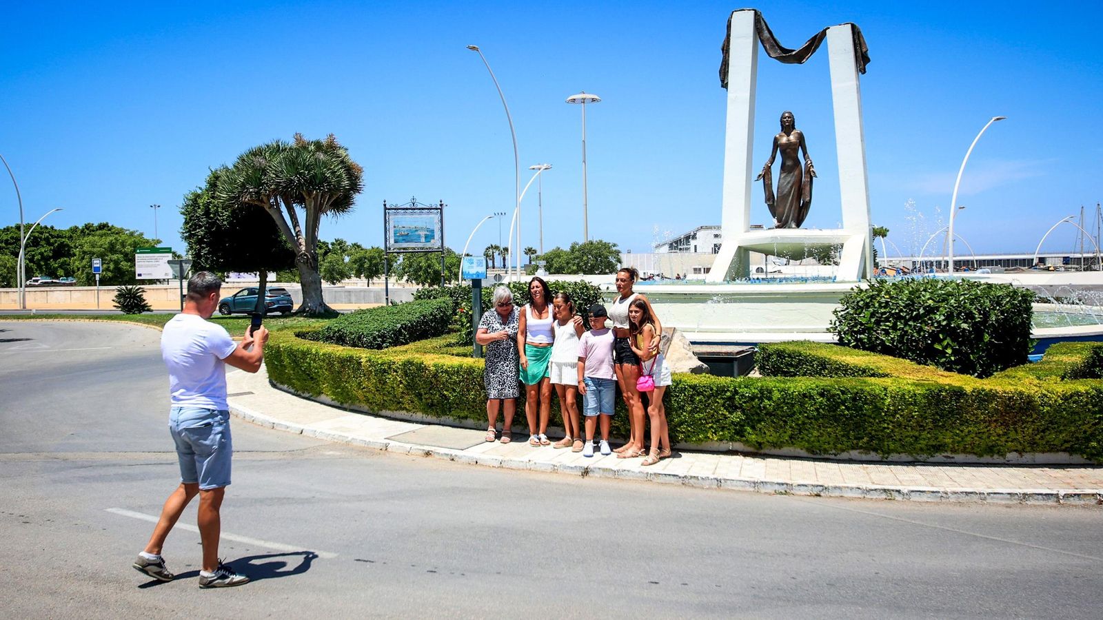 Turistas fotografiándose a los pies del monumento de Rocío Jurado, en Chipiona (Cádiz).