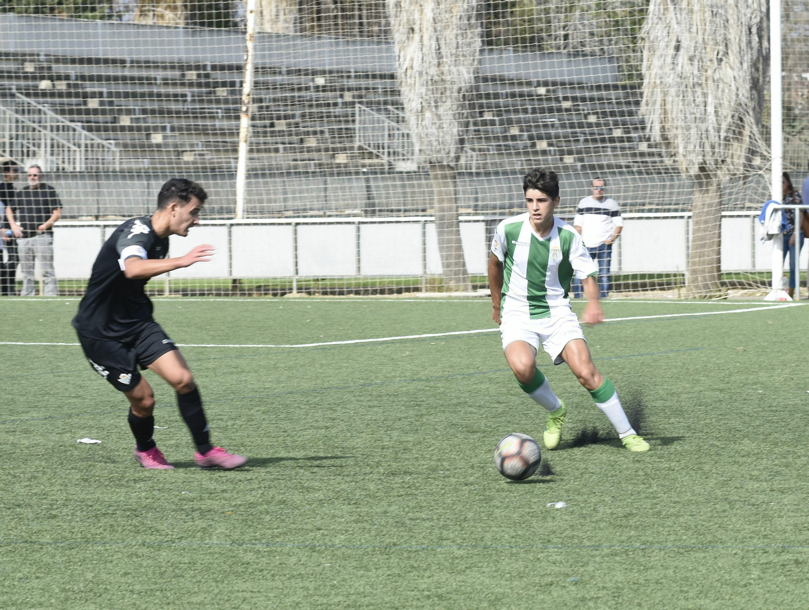 Un jugador del Córdoba trata de controlar el balón en presencia de un jugador del Betis.