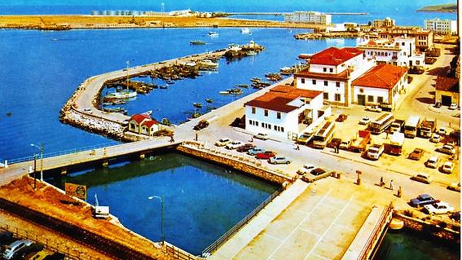 El efímero “Puente Nuevo del río de La Miel”, a su izquierda el puente de la desembocadura en su última fase.  Mas allá, la dársena de embarcaciones menores y el antiguo Club Náutico. En primer término, la vía del ferrocarril que accedía al muelle de pasajeros.