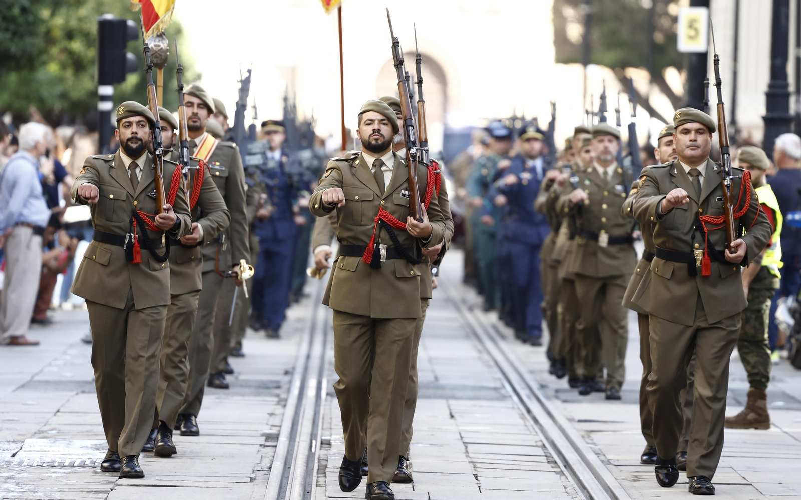 El izado de bandera y desfile militar por el centro de Sevilla, en imágenes