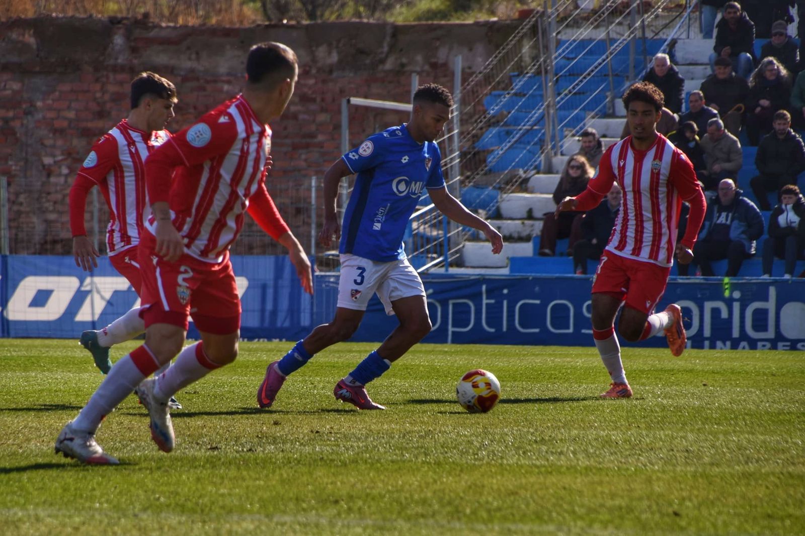 El local Manny conduce el balón ante la presión de varios jugadores del conjunto rojiblanco.