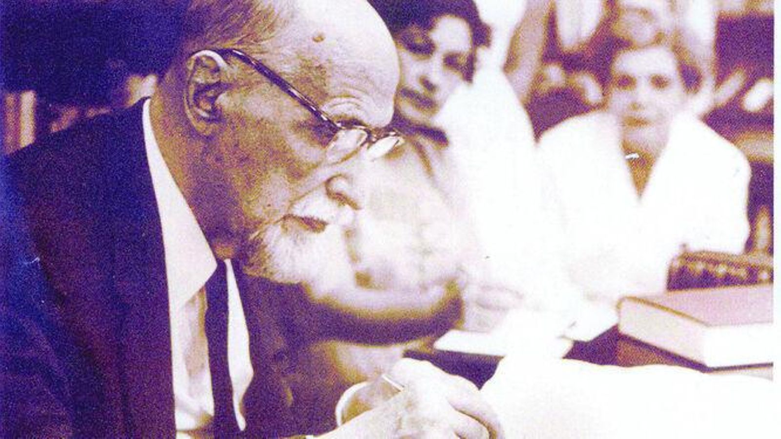 Juan Ramón Jiménez firma una dedicatoria en un libro.