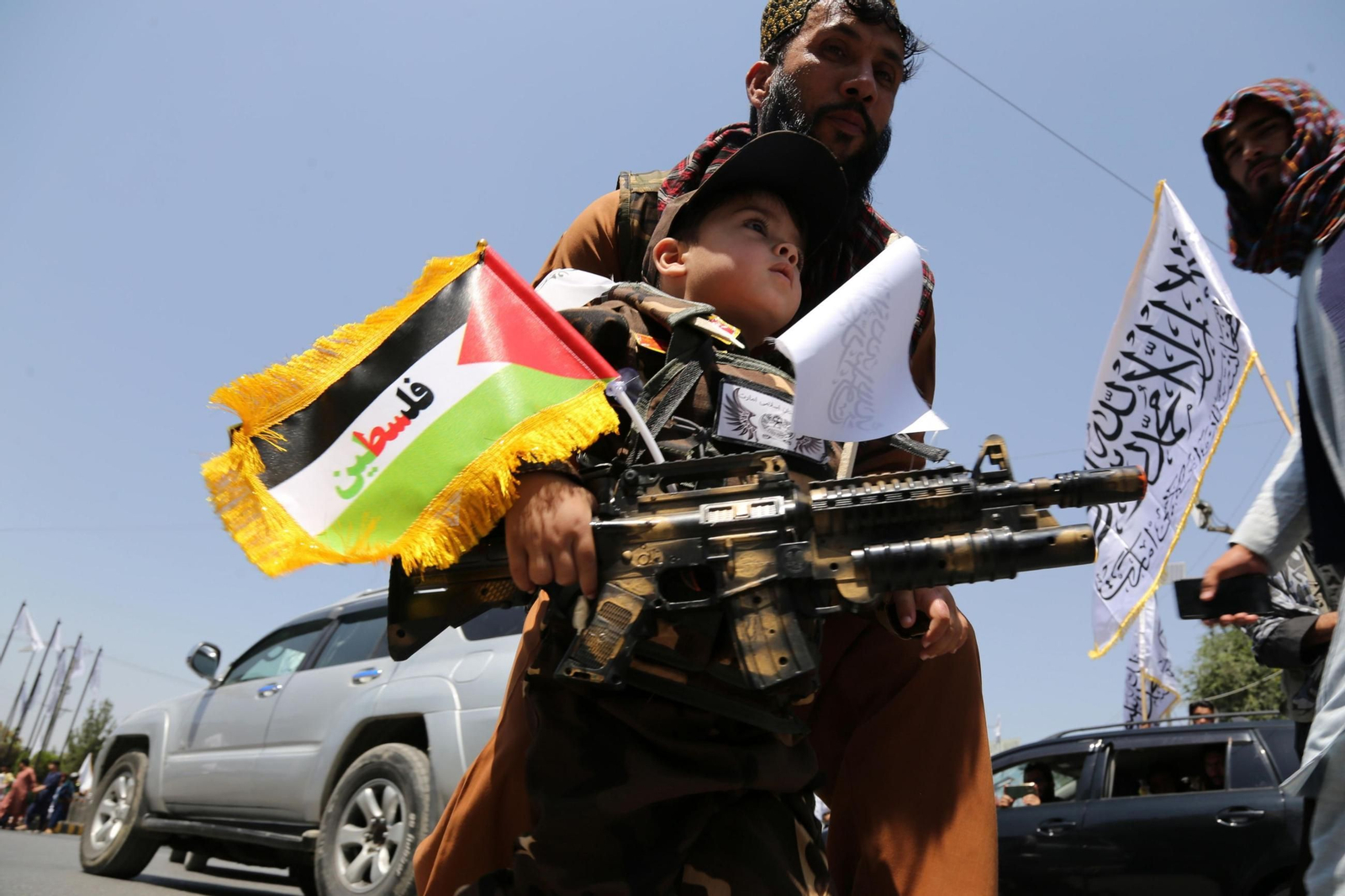 Un hombre armado que porta en sus brazos a un niño celebra en Kabul el tercer aniversario de la toma de posesión de los talibanes en Afganistán. Un hombre armado que porta en sus brazos a un niño celebra en Kabul el tercer aniversario de la toma de posesión de los talibanes en Afganistán.