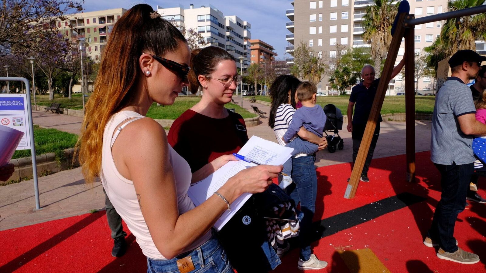 Decenas de familias en el parque de la Plaza Bizet firman el documento que se va a presentar ante la Delegación.