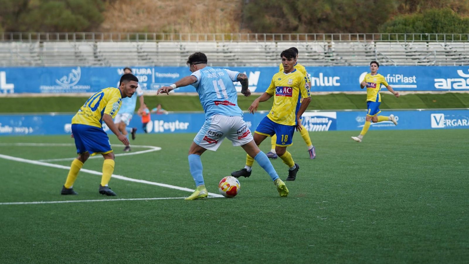 Joselyyo controla el balón en presencia de dos rivales.
