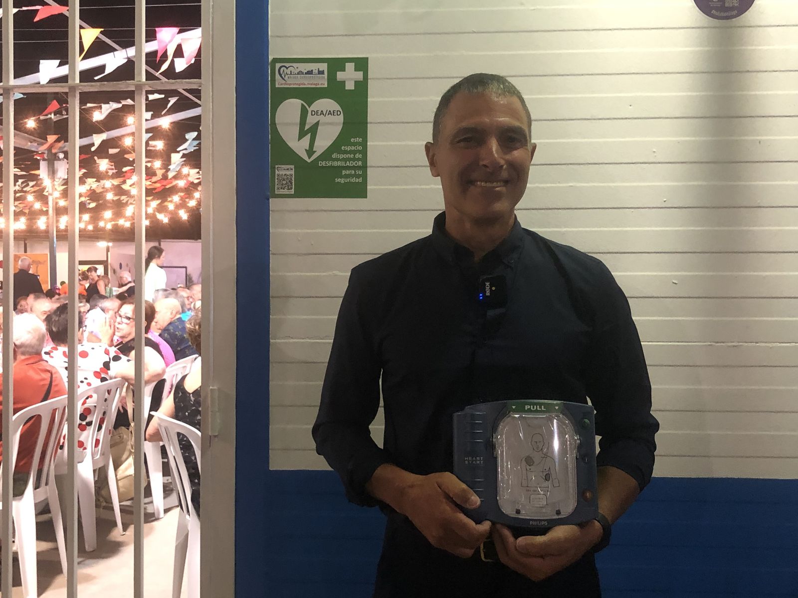 Jesús Toscano, técnico de los desfibriladores en el Ayuntamiento, posa con un aparato en el Real de la Feria.